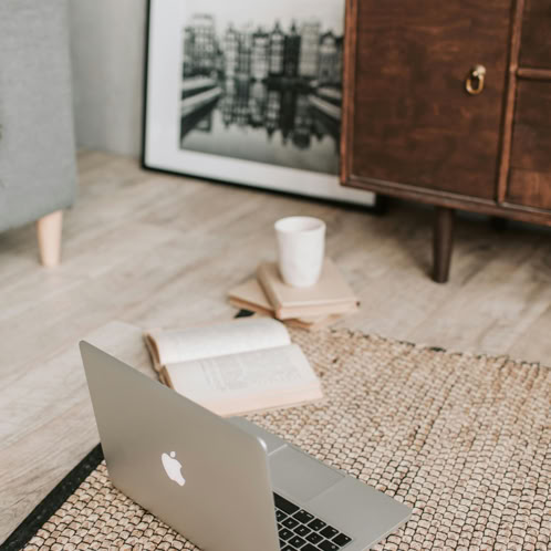 Laptop and books on floor carpet